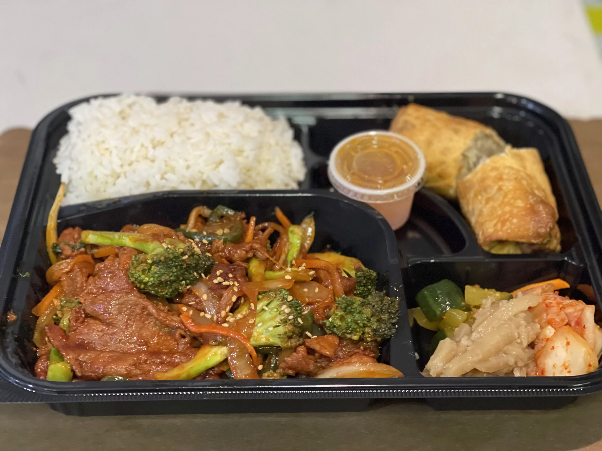 A personal bento filled with rice, spicy bulgogi, and some traditional Korean sides from Cana Korean Restaurant