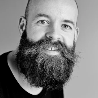 A young man with a full beard posing for a photo for a review of Cana Korean Restaurant
