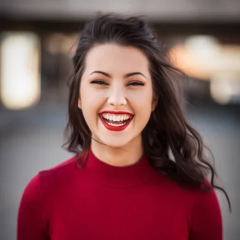 A young woman wearing a red shirt, posing for a photo for a review for Cana Korean Restaurant