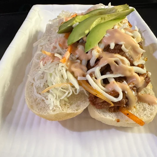 Cana Korean Restaurant's unique and special item, the bulgogi sandwich, topped with veggies, avocado, and a secret sauce